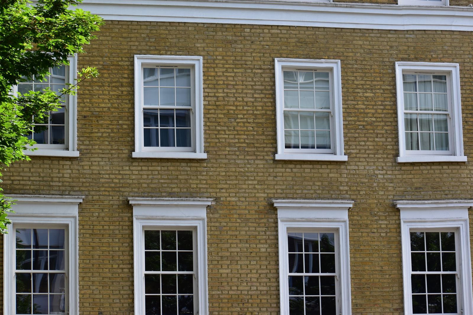 A London stock brick frontage with white-framed sash windows