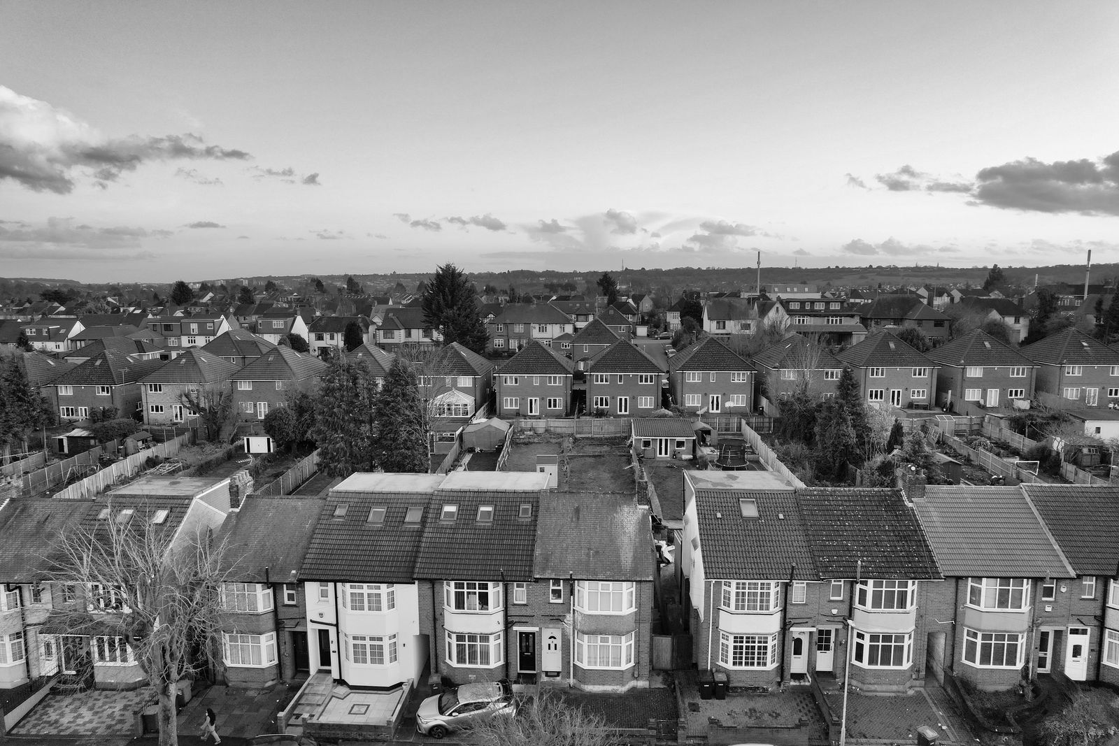 An aerial view of rows of English semi-detached and terraced houses with back gardens between them