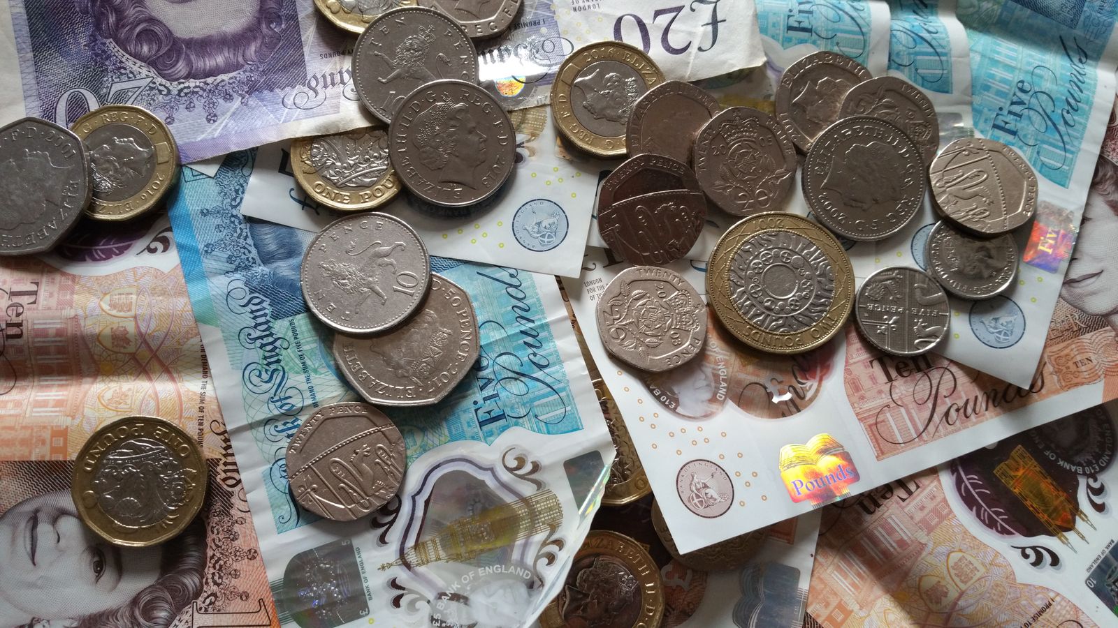 British banknotes and coins spread across a surface
